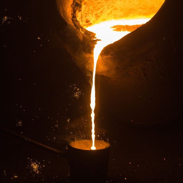 Molten gold being poured during fire assay — the most accurate but destructive purity test