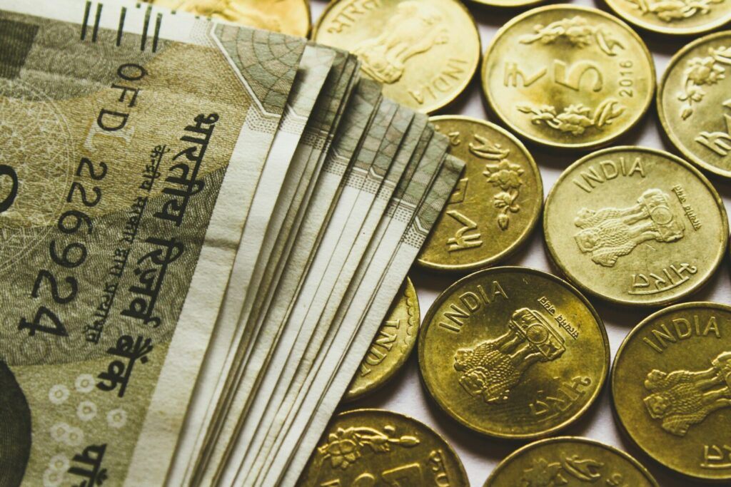 Indian rupee notes and gold coins representing live domestic gold rate used in gold valuation